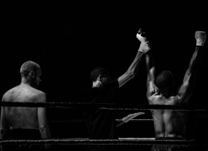 The referee holds up the winners hand after a boxing match