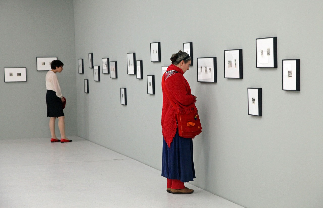A woman closely examining a picture in a gallery